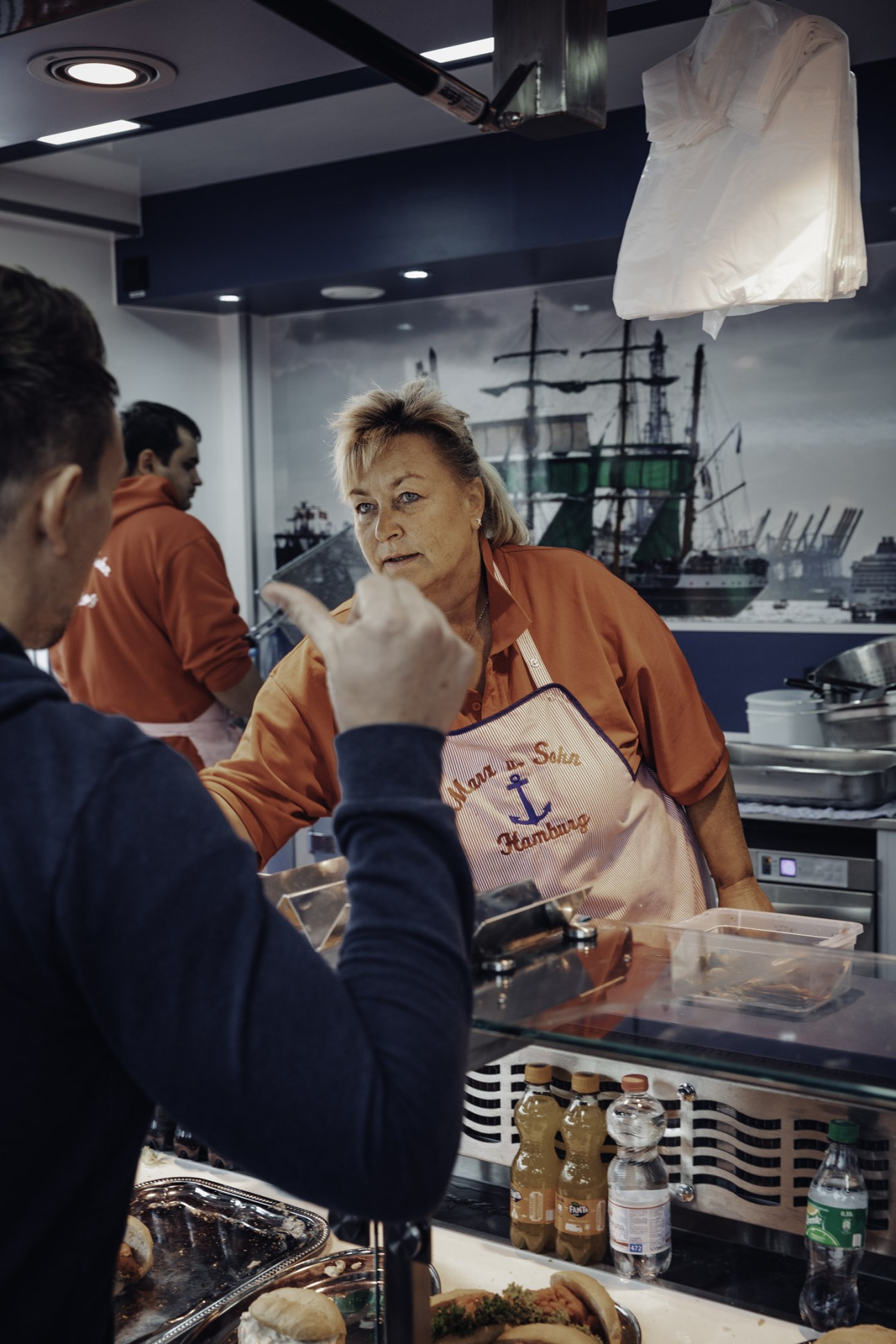 Regina wearing a Marx & Sohn apron serves Fischbrötchen at the Hamburg Fish Market stall.