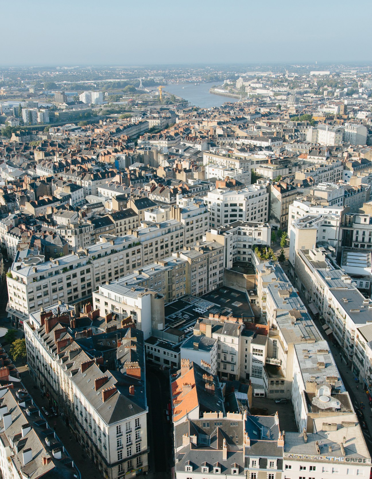 Aerial view of Nantes showing the Loire River winding through the city with dense urban architecture and buildings.