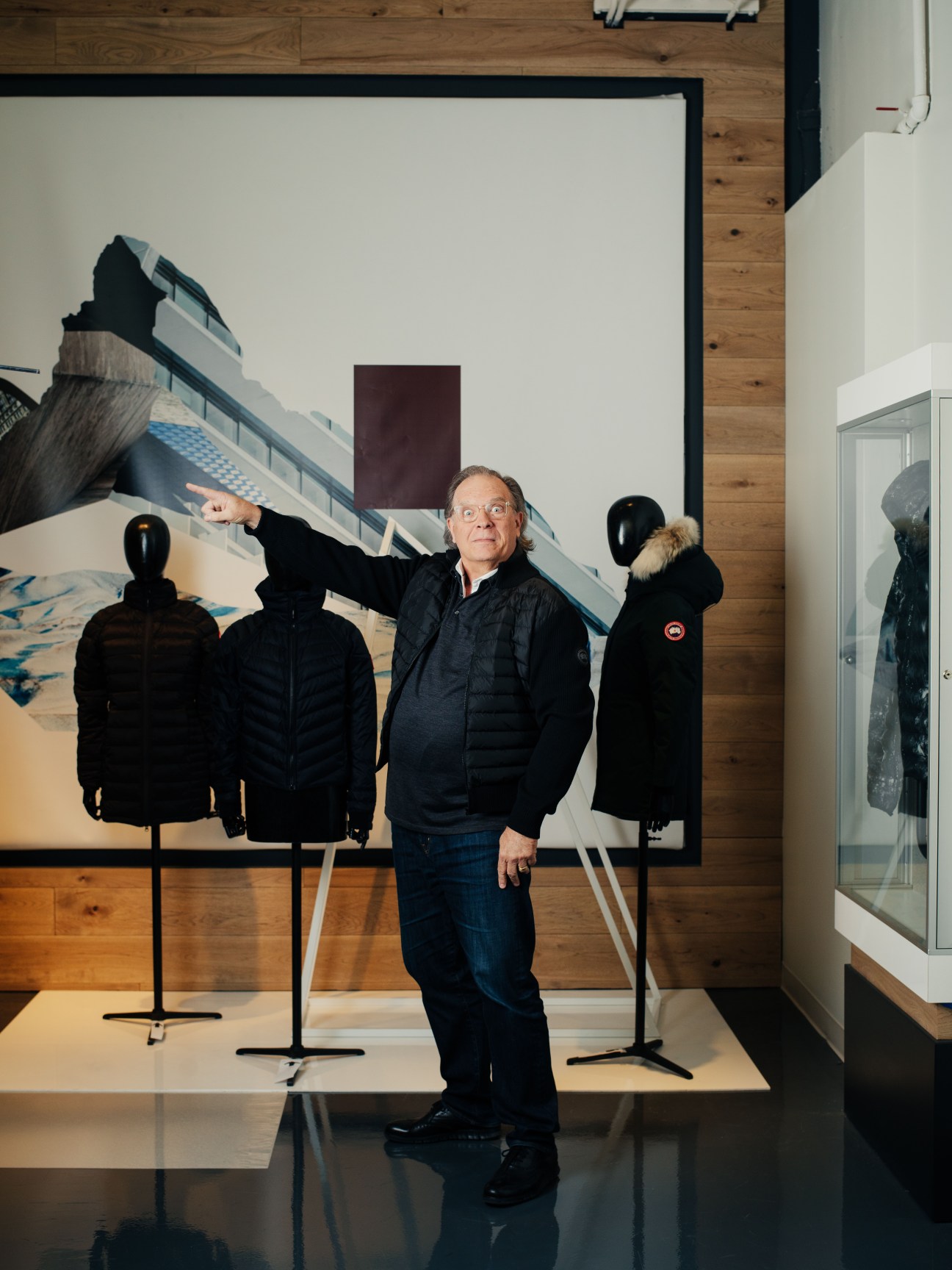 Lee Turlington, chief product officer, poses in Canada Goose jacket among mannequins wearing parkas in showroom