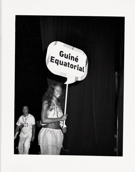 Woman holding a sign reading 'Guiné Equatorial' at the opening ceremony of the Jogos da Lusofonia.