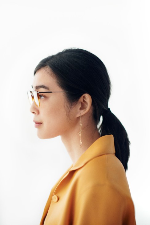Woman in profile wearing a yellow Hermès jacket, Prada glasses, and Sarah & Sebastian earring.