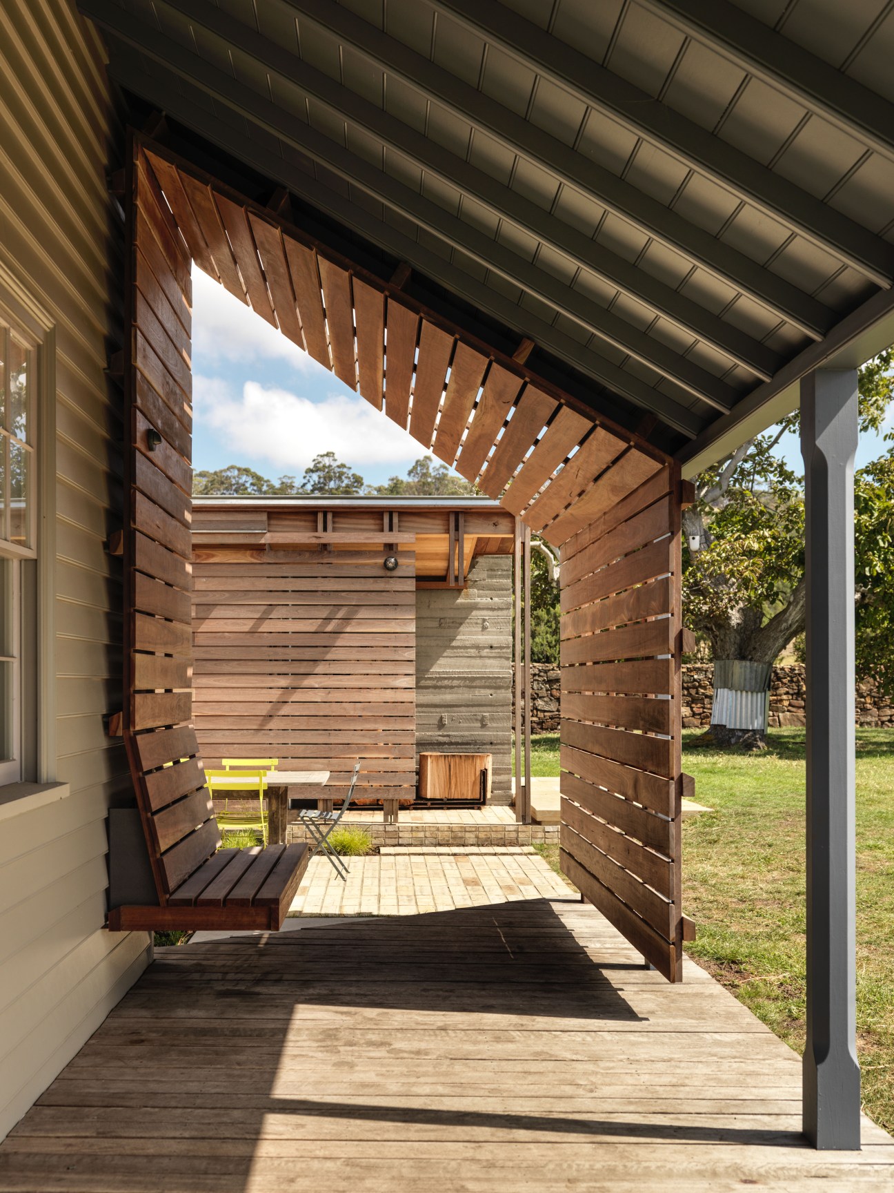 Rebuilt verandah with retractable wooden shutters and modern metal roof on Captain Kelly's Cottage.