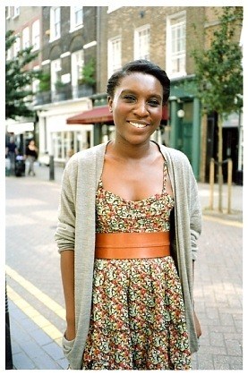 Florence Laud-Anderson, a resident of Lamb's Conduit Street, smiling on the street with Victorian buildings behind her.
