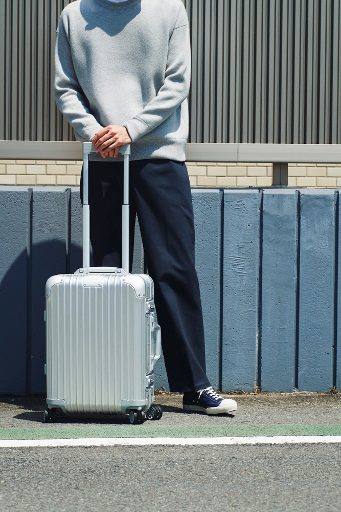 Travel-ready outfit with sweatshirt, trousers and designer suitcase