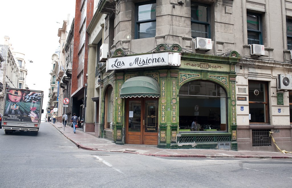 Historic green storefront of Las Misiones café on a street corner in Montevideo's Old City.