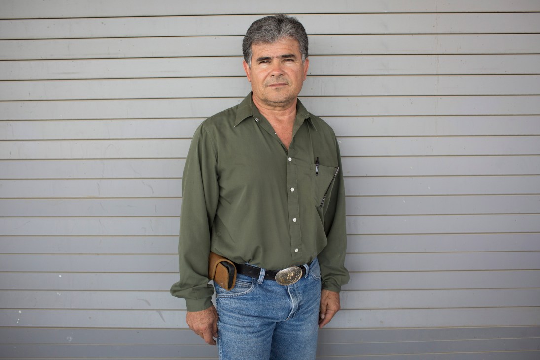 Manuel Peralta, Imperial Date Gardens' senior agronomist, stands against a white corrugated wall.