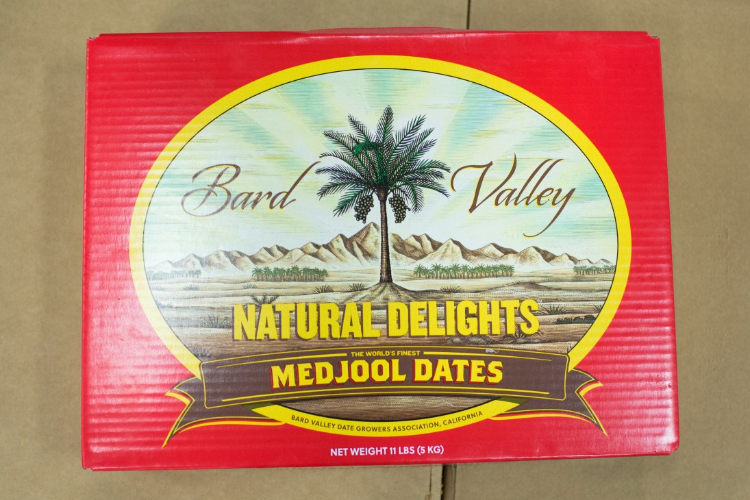 Bard Valley Natural Delights medjool dates box with desert landscape and date palm illustration.