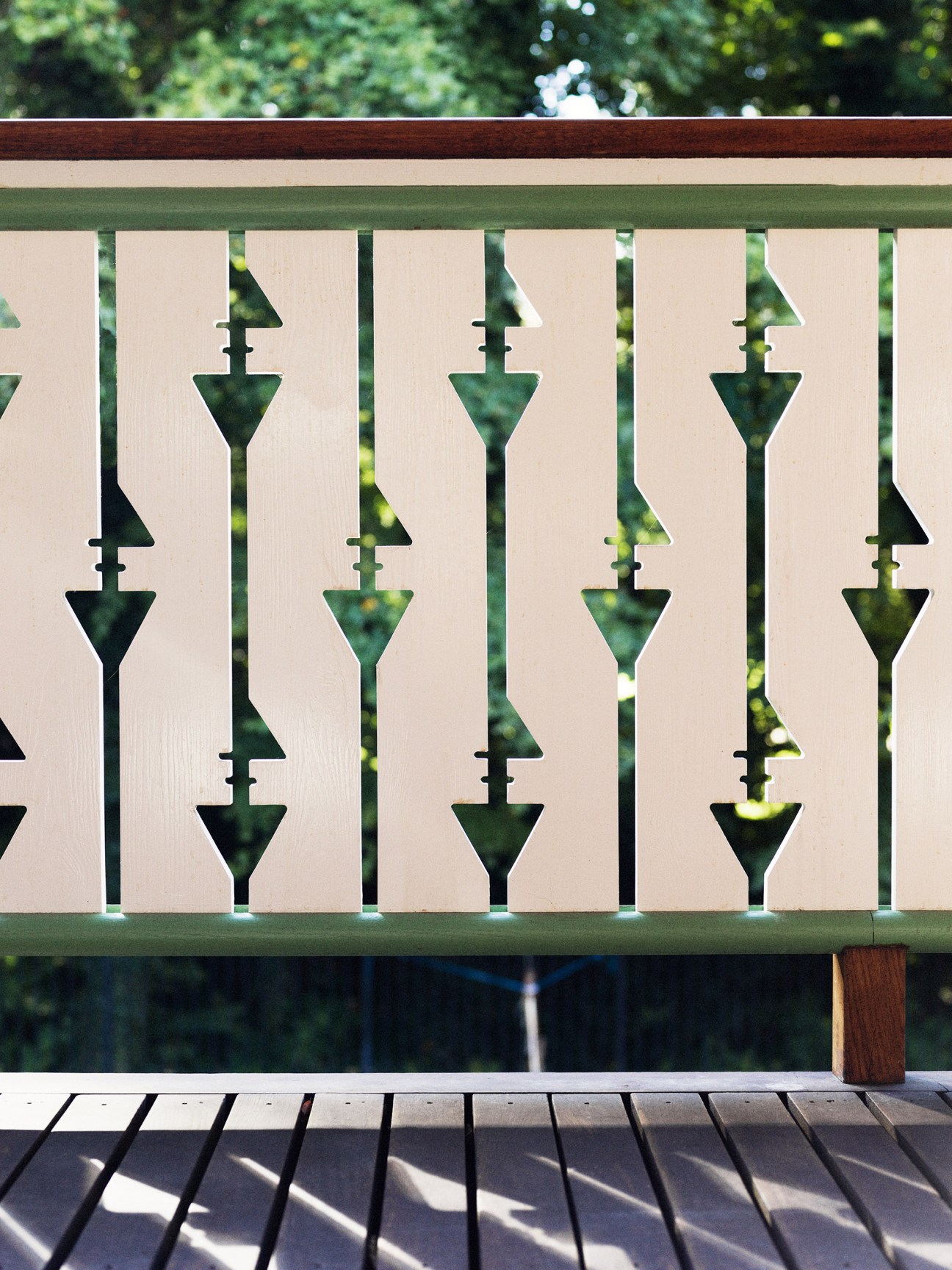 Green geometric balcony railing forming the numbers '4' and Roman numeral 'V' at 4th May College in Copenhagen.