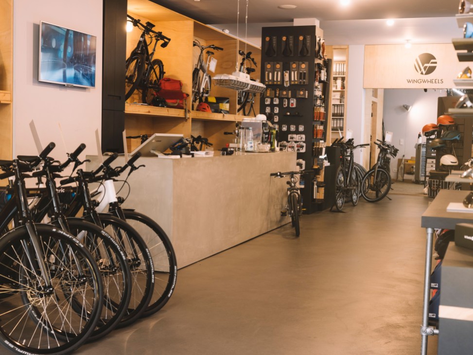 Interior of Wingwheels e-bike shop in Berlin displaying bikes, components, and retail merchandise.