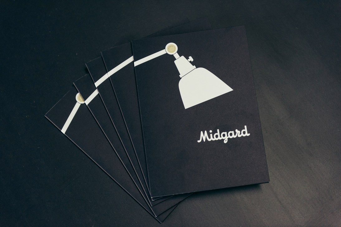 Vintage Midgard branding materials featuring the company logo and an adjustable lamp illustration on black covers.