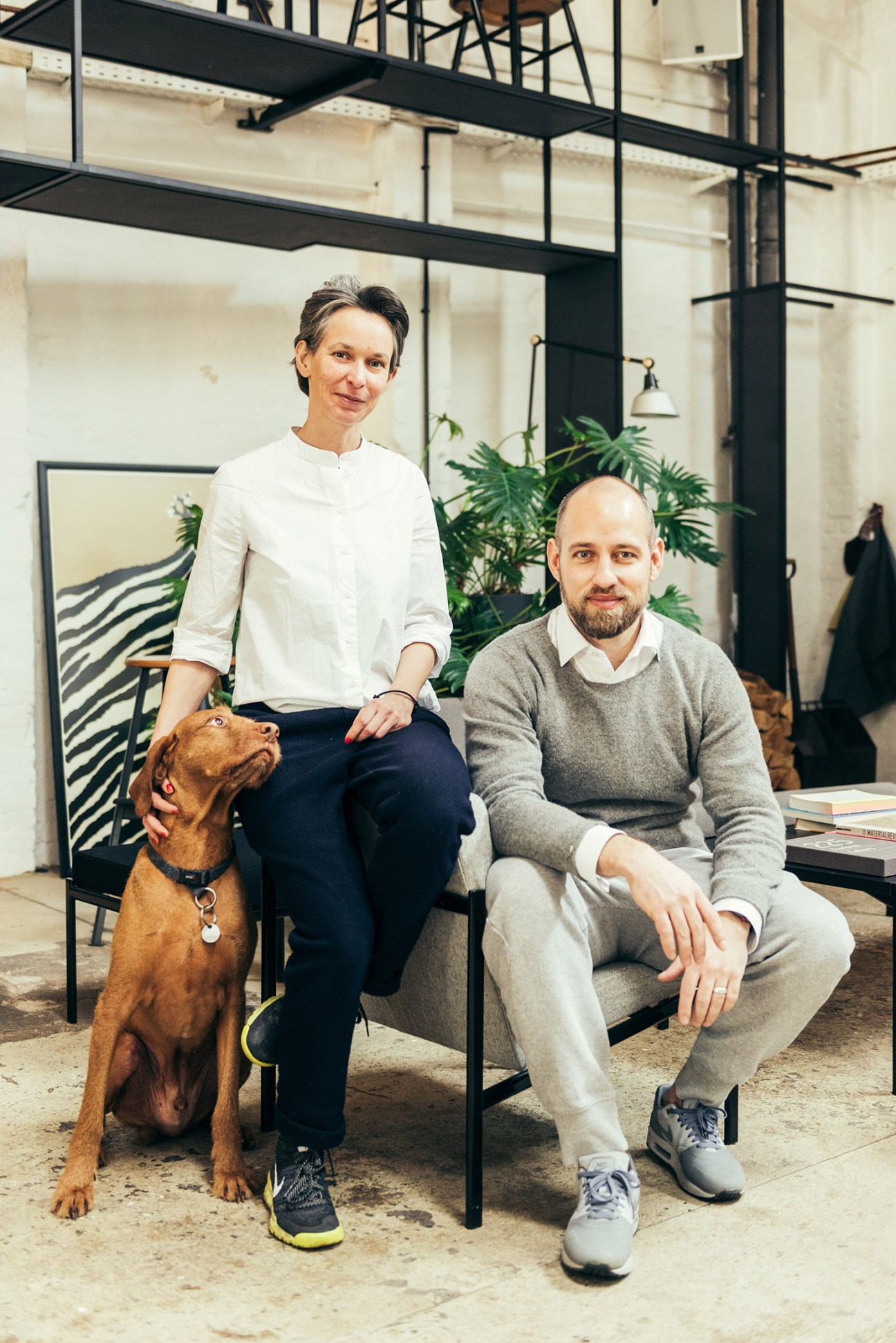Joke Rasch, David Einsiedler and their vizsla dog Laban pose in the Ply Lab showroom in Hamburg.