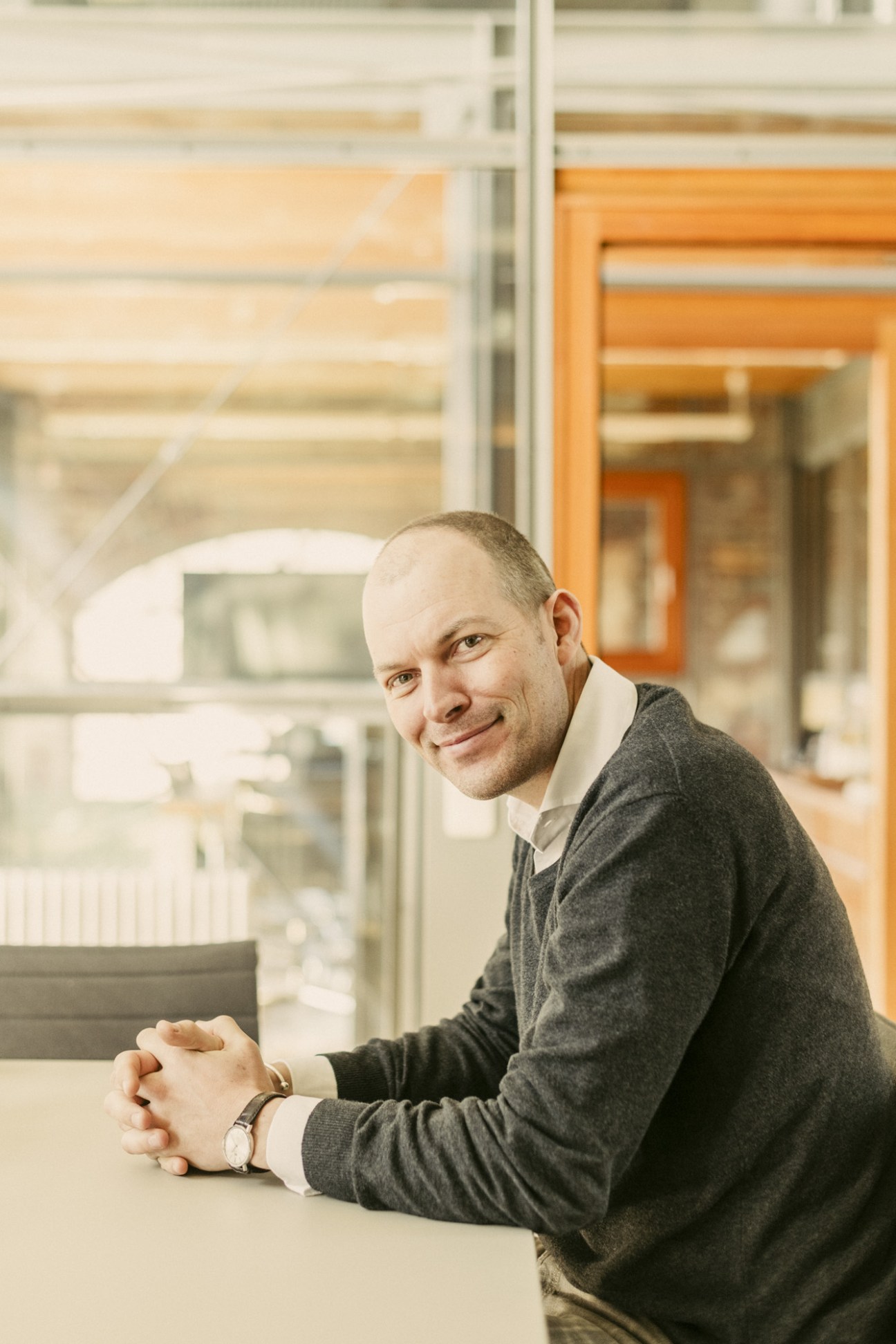 Max Heimann, Manufactum's managing director, seated at a desk in a glass office cube within the converted colliery headquarters.
