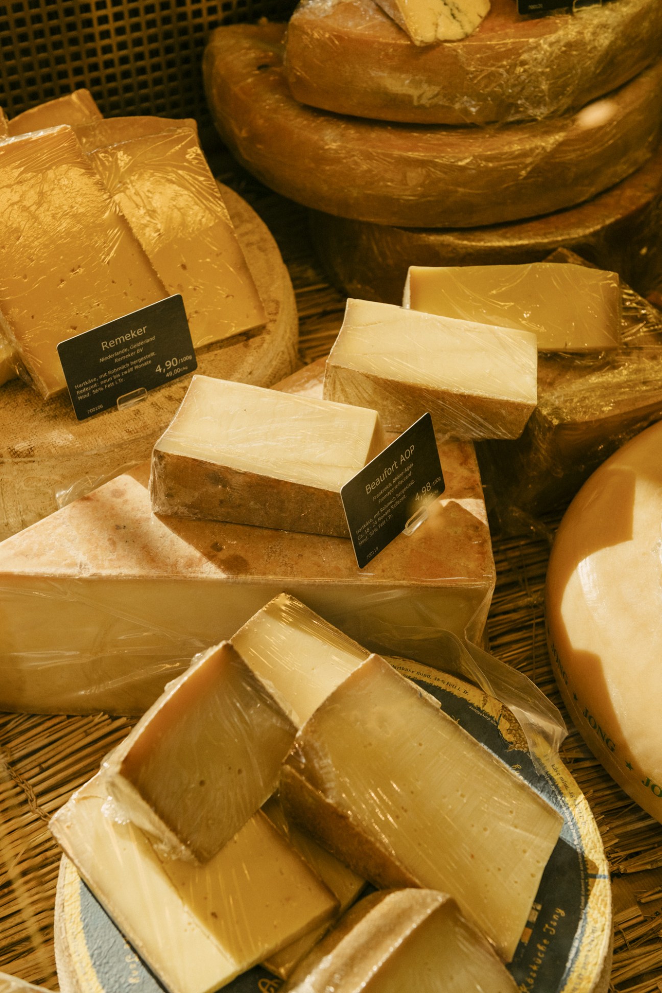 Brot&Butter's artisanal cheese selection displayed with product labels on wooden surface.