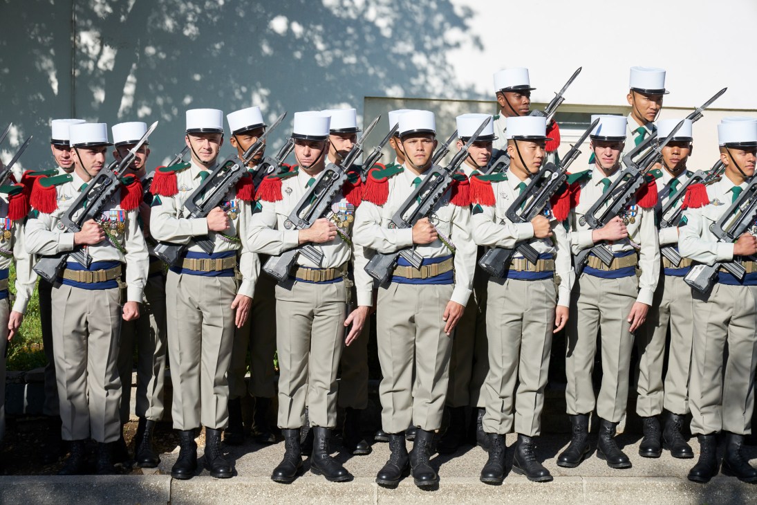 French Foreign Legion soldiers in formal dress uniform standing at attention during the military command 'Garde à vous'