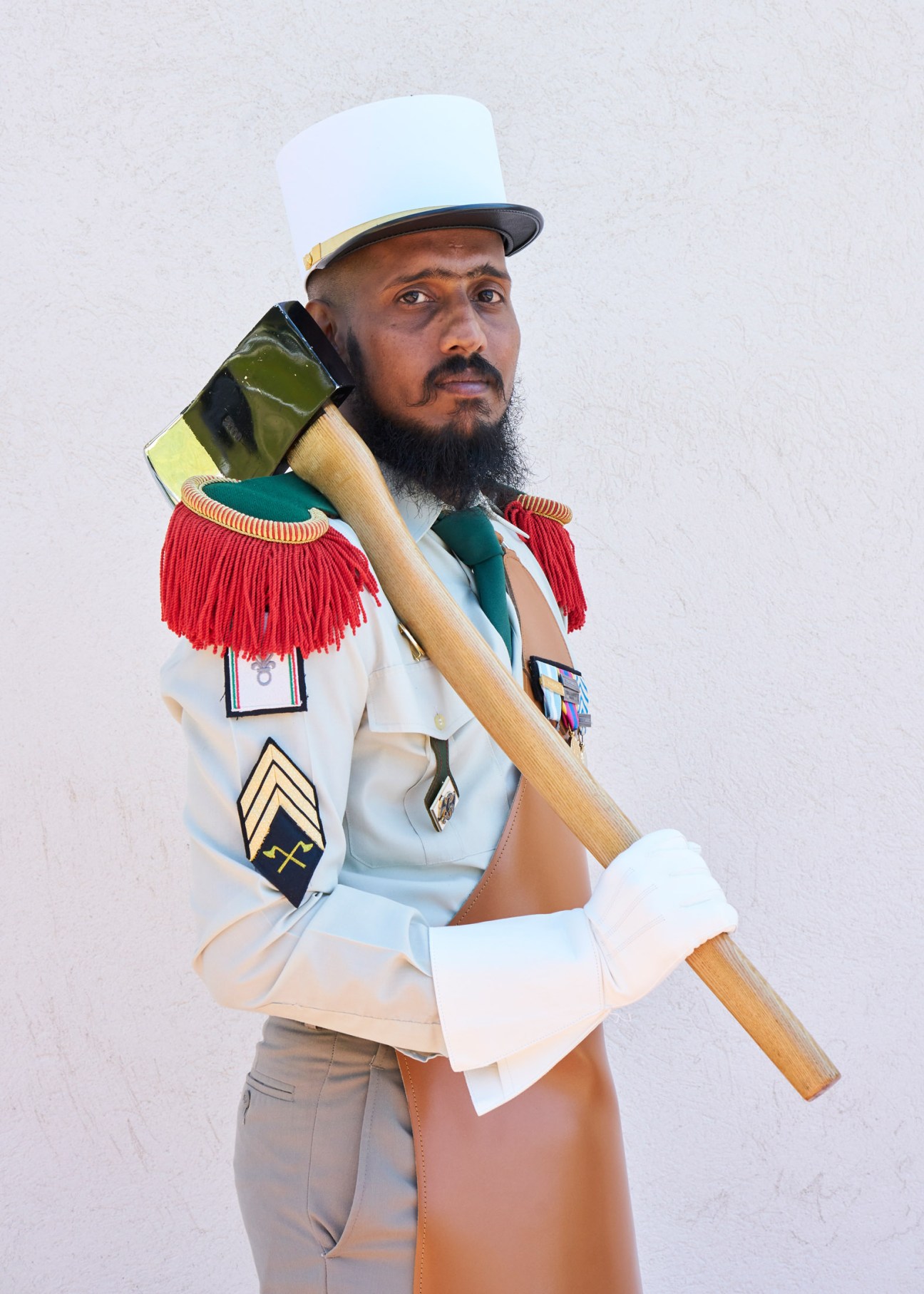 French Foreign Legion Pioneer in dress uniform with white képi blanc, red épaulettes, leather apron and polished axe