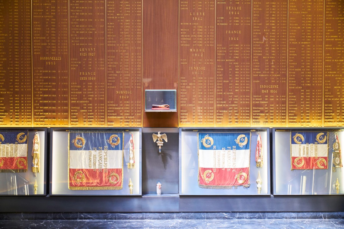 Museum display case showing military regimental flags and Captain Jean Danjou's wooden prosthetic hand.