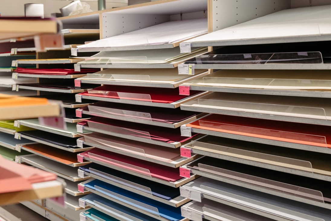 Stacked shelves displaying colorful paper and materials at Modulor stationery shop in Berlin.