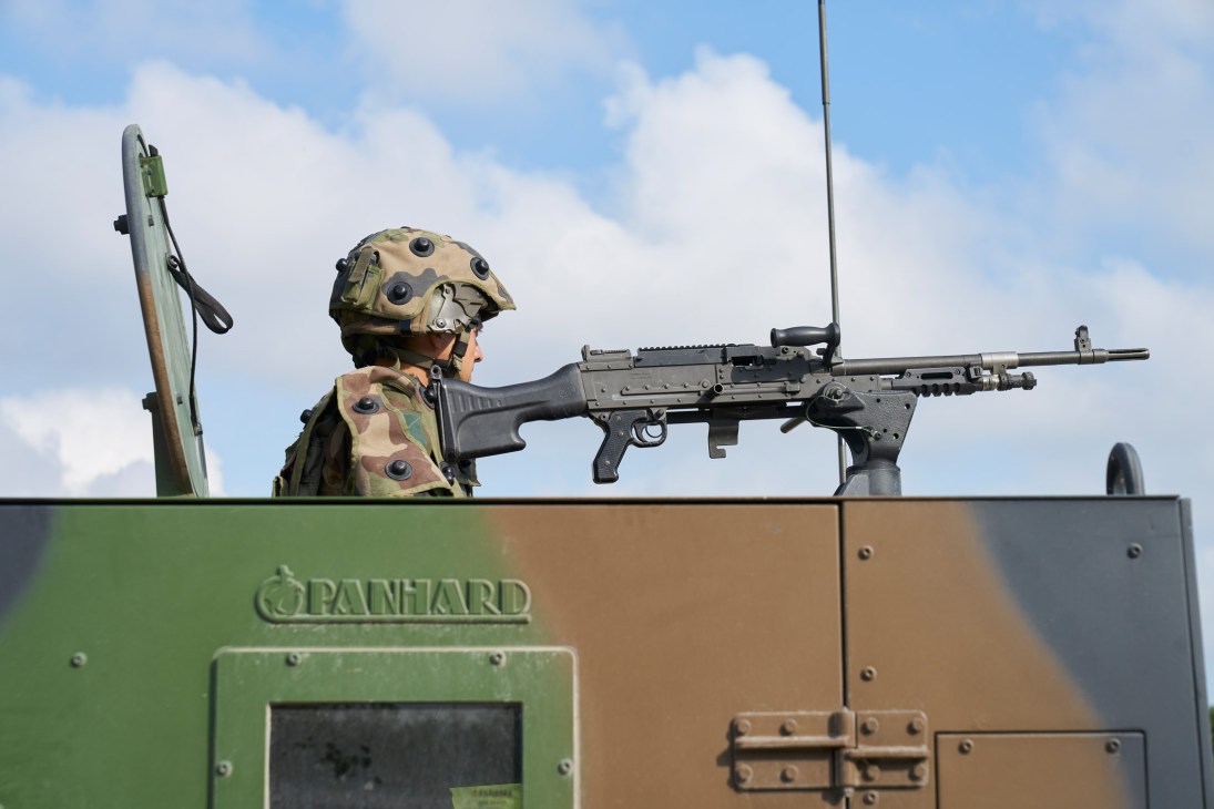Legionnaire operating a mounted machine gun from inside a Panhard armored vehicle during training.