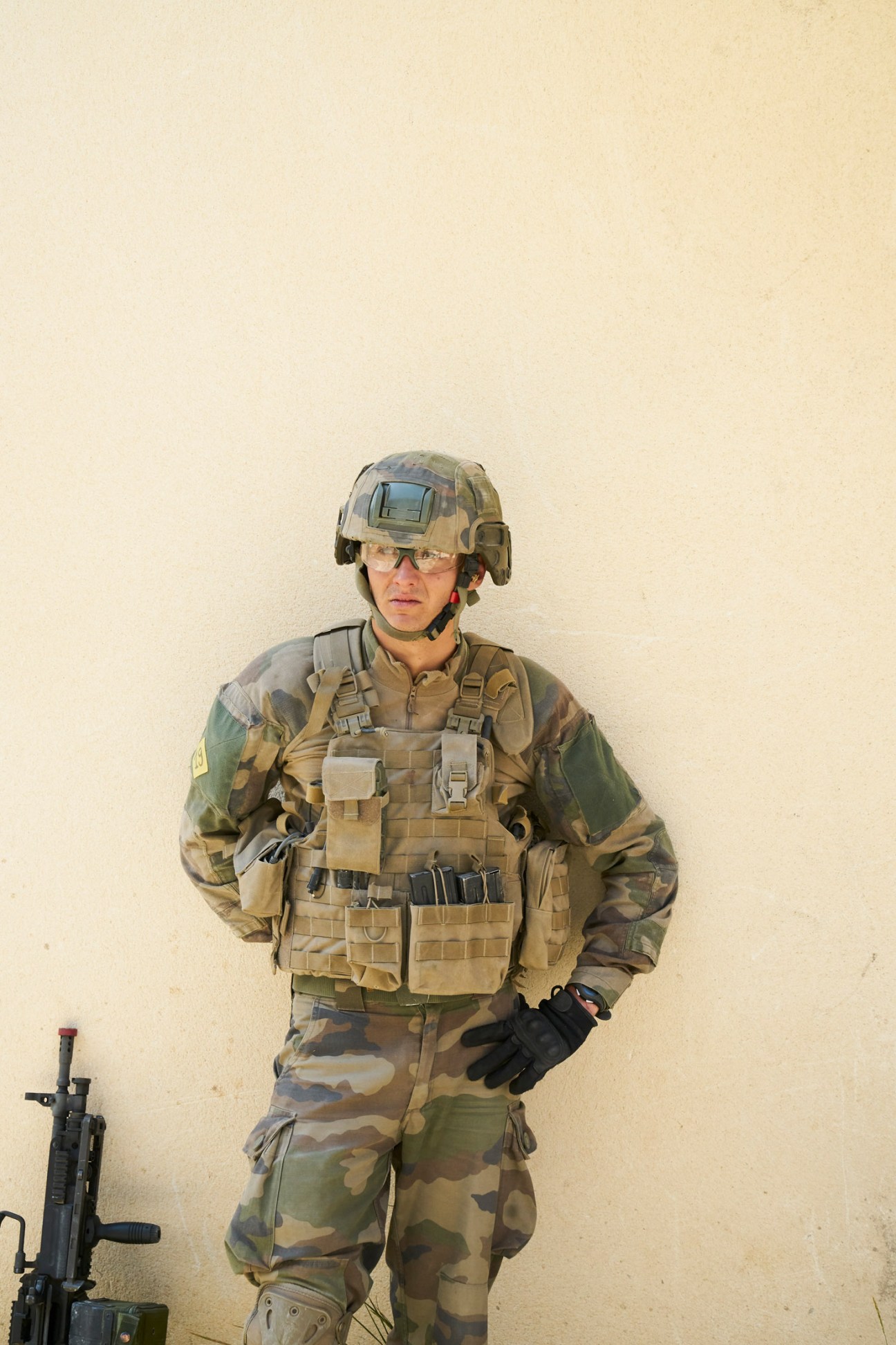French Foreign Legion soldier in camouflage uniform and tactical gear standing guard during training exercise.