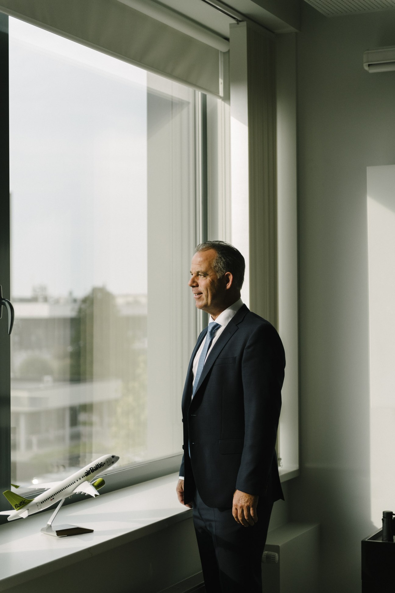 Martin Gauss, AirBaltic CEO, standing by a window with an aircraft model on the sill