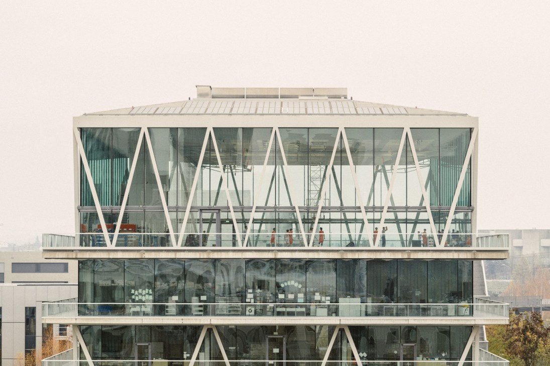 Modern multi-story school building with geometric white frame design and large glass windows.
