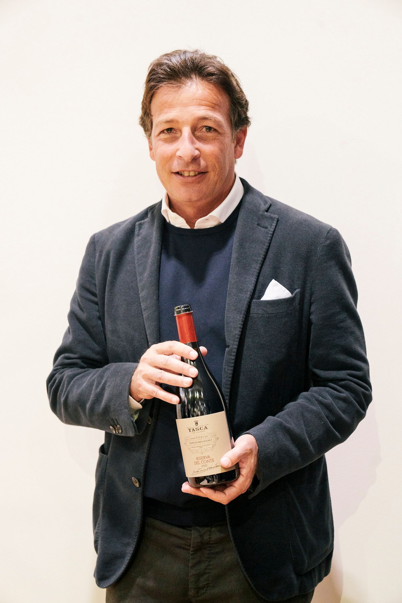 Alberto Tasca holds a bottle of Tasca wine at Vinitaly in Verona.