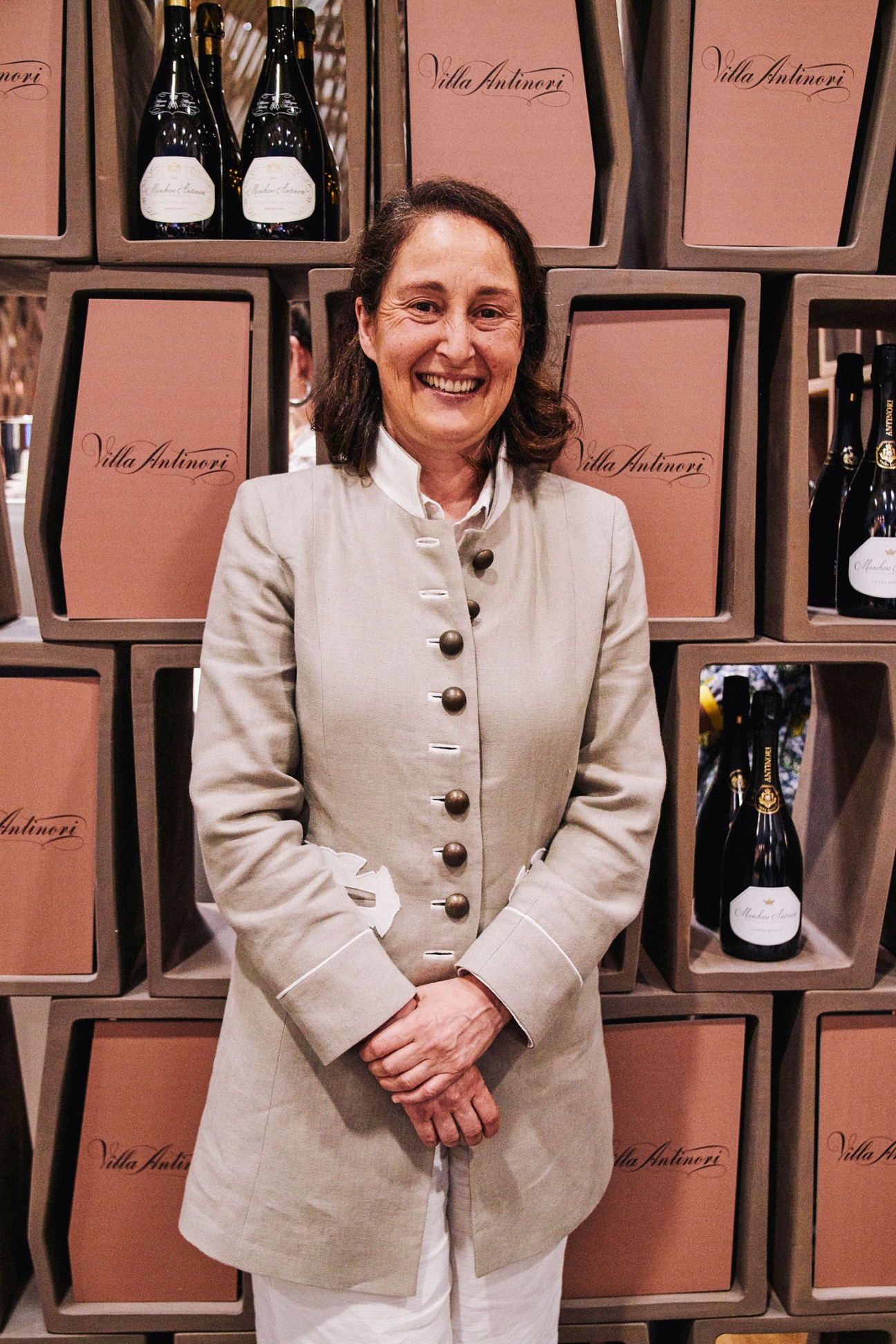 Albiera Antinori, president of Antinori winery, smiling in front of Villa Antinori branded display boxes at Vinitaly.