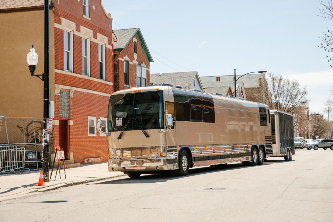 Calexico's tour bus parked outside a brick building in Chicago.