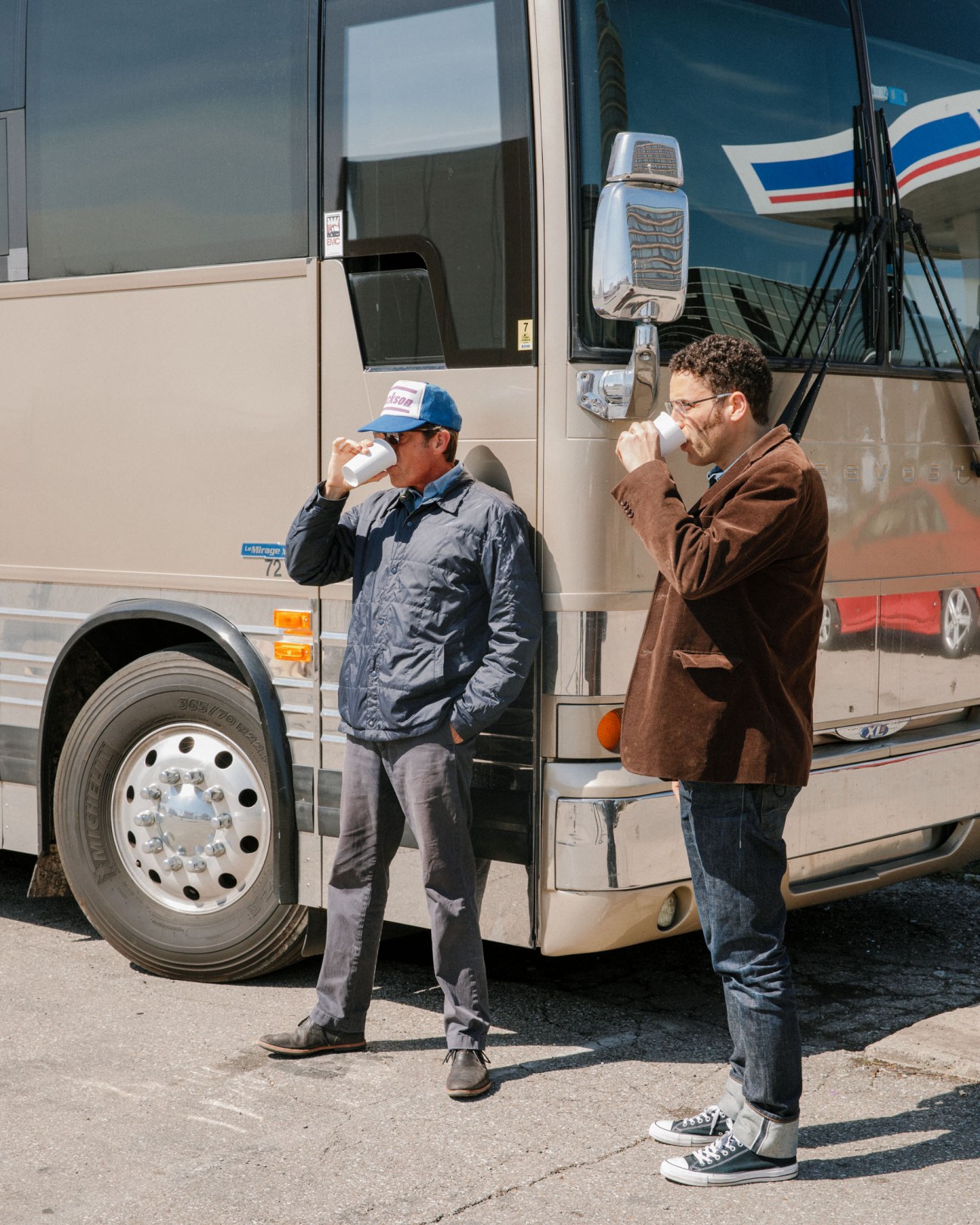 Two men drinking coffee outside a tour bus in Cincinnati, Ohio.