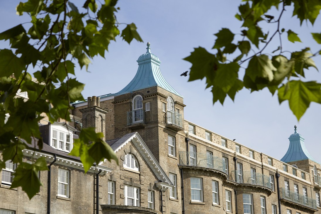 University Arms Cambridge hotel exterior showing distinctive turret with copper roof and ivy-covered stone facade.