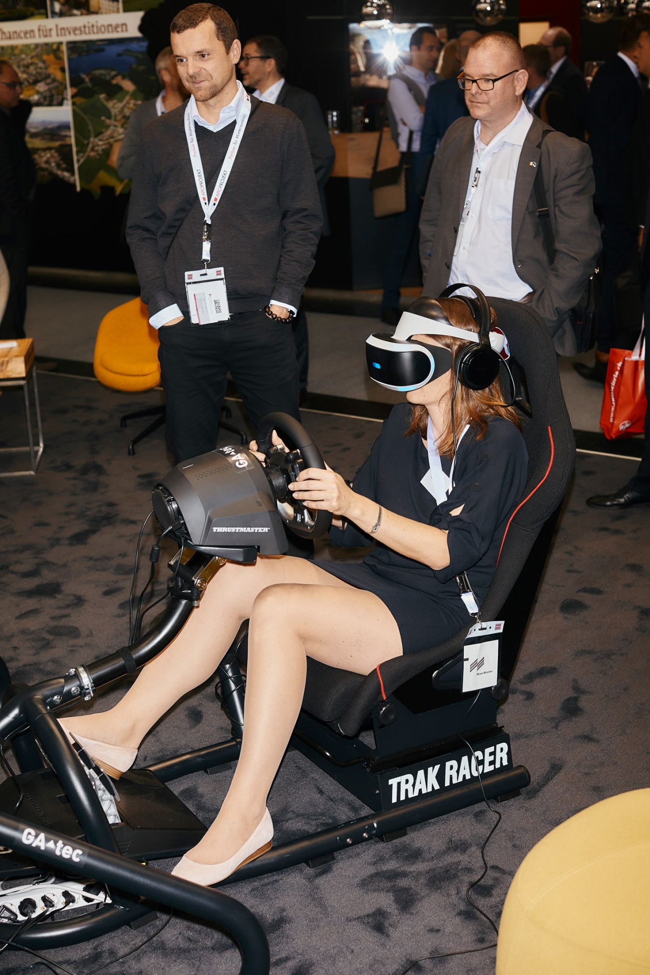 Woman wearing VR headset on racing simulator at Expo Real trade fair booth