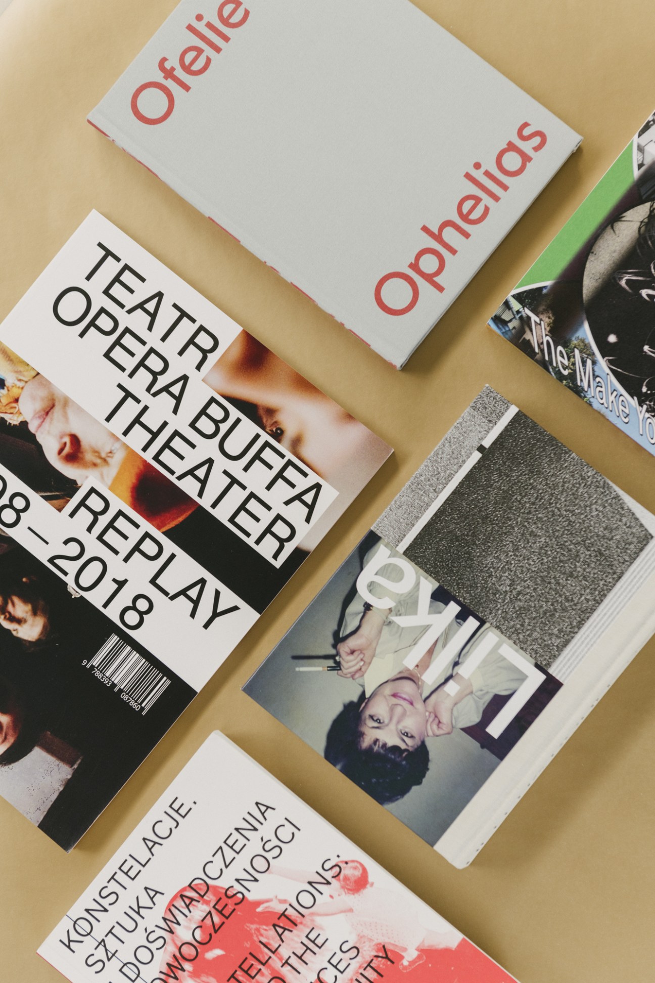 Overhead view of various printed publications and design materials on a beige surface.
