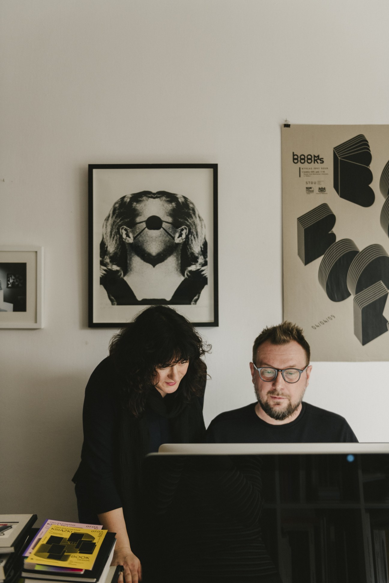 Magdalena Frankowska and Artur Frankowski of design studio Fontarte in their workspace with graphic designs on the wall.