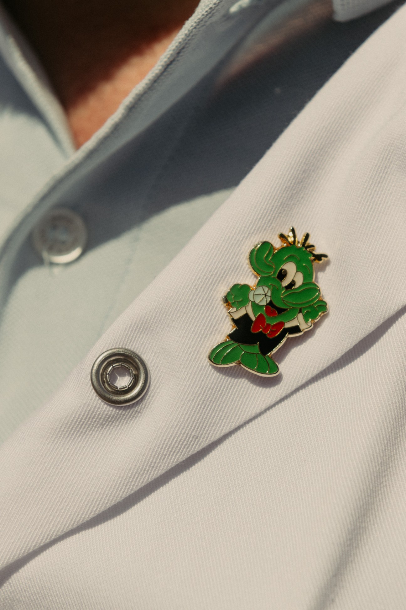 Yuppi the cartoon cactus mascot badge pinned to a white staff uniform.