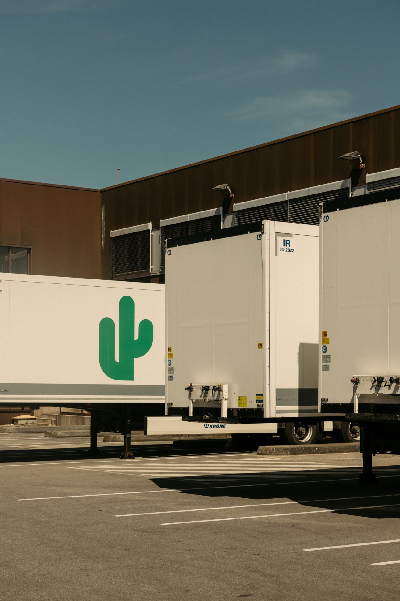 Cactus delivery truck with green cactus logo on white refrigerated trailer.