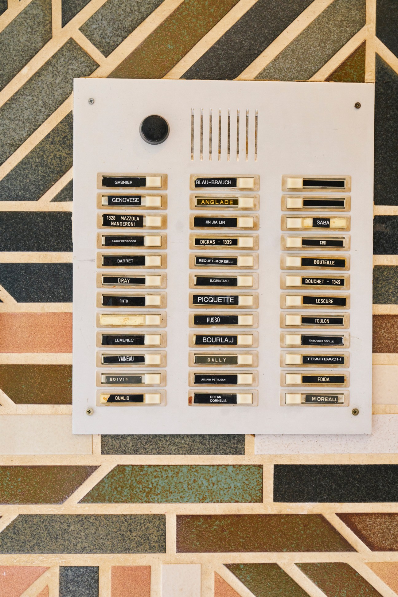 Panel of apartment buzzers and nameplates outside building entrance