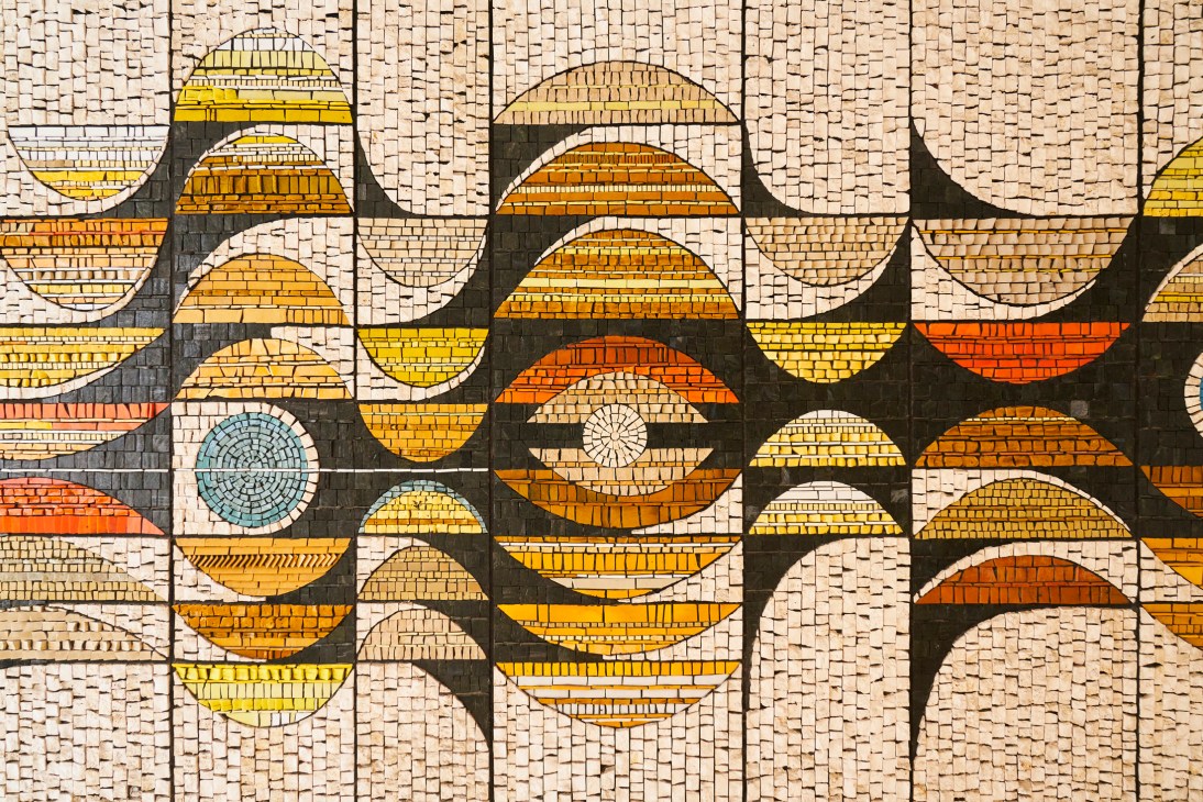 Colorful geometric mosaic artwork at building entrance with Mediterranean design motifs