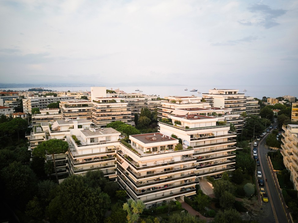 Aerial view of massive Mas de Tanit apartment complex showing 15 angular blocks across forested hillside