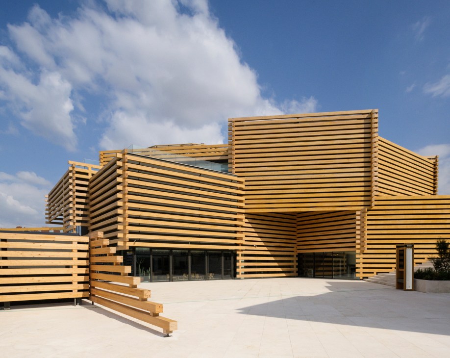 Odunpazari Modern Museum exterior with stacked wooden beam facades and glass windows under blue sky.