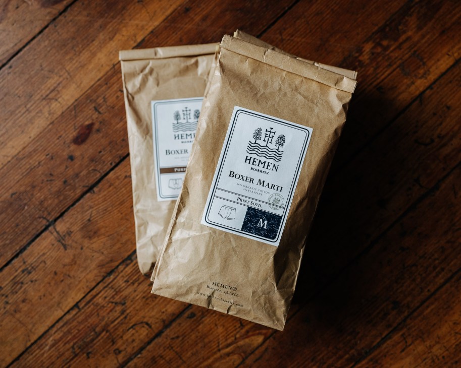 Two kraft paper packages of Hemen boxer marti underwear with printed labels on a wooden floor.
