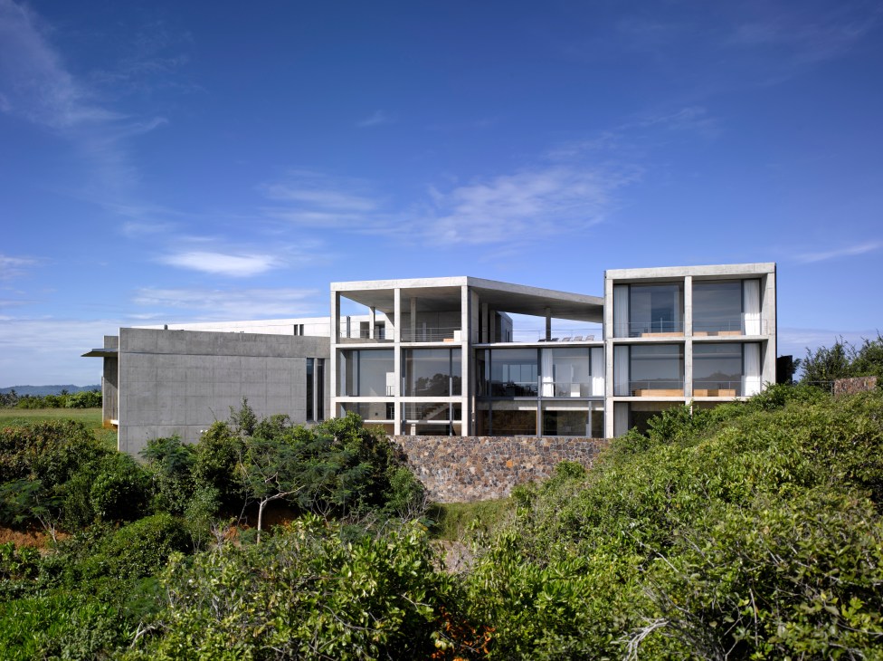 Tadao Ando-designed concrete house with floor-to-ceiling windows surrounded by lush tropical vegetation on Sri Lanka's southern coast.