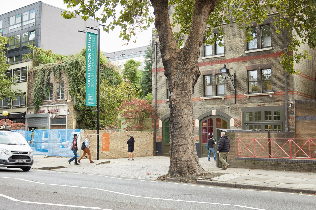 South London Gallery exterior with historic brick building, green banner, and modern extension visible.