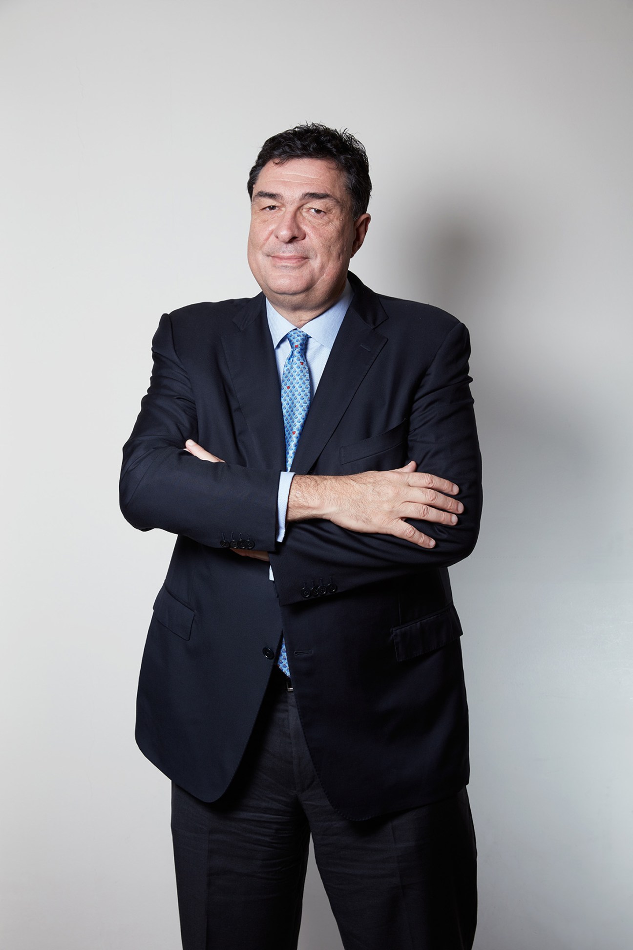 Portrait of Alexis Papahelas, executive editor of Kathimerini newspaper, in a dark suit and blue tie.