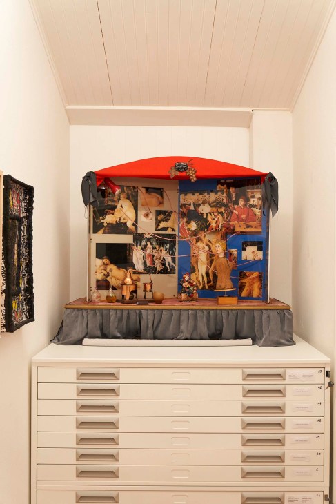 Fluxus artwork by Ben Patterson with red canopy and collaged images that responds to opera music.