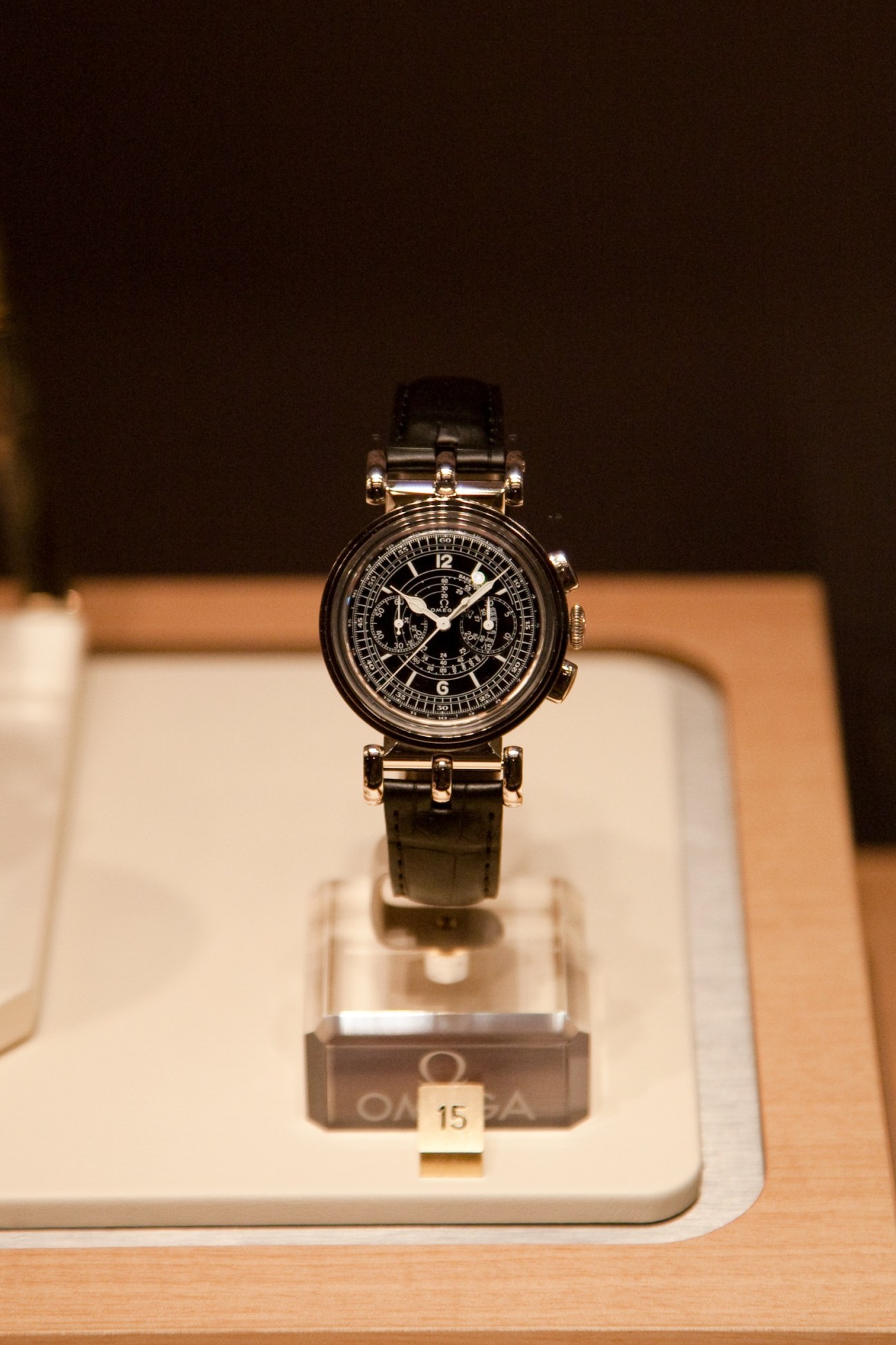 Re-edition of Omega's Milestone 1941 watch displayed on a white stand with black leather strap.