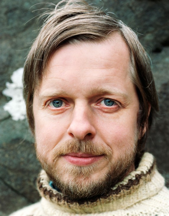 Portrait of Faroese musician Teitur Lassen wearing a knit sweater against a textured background.