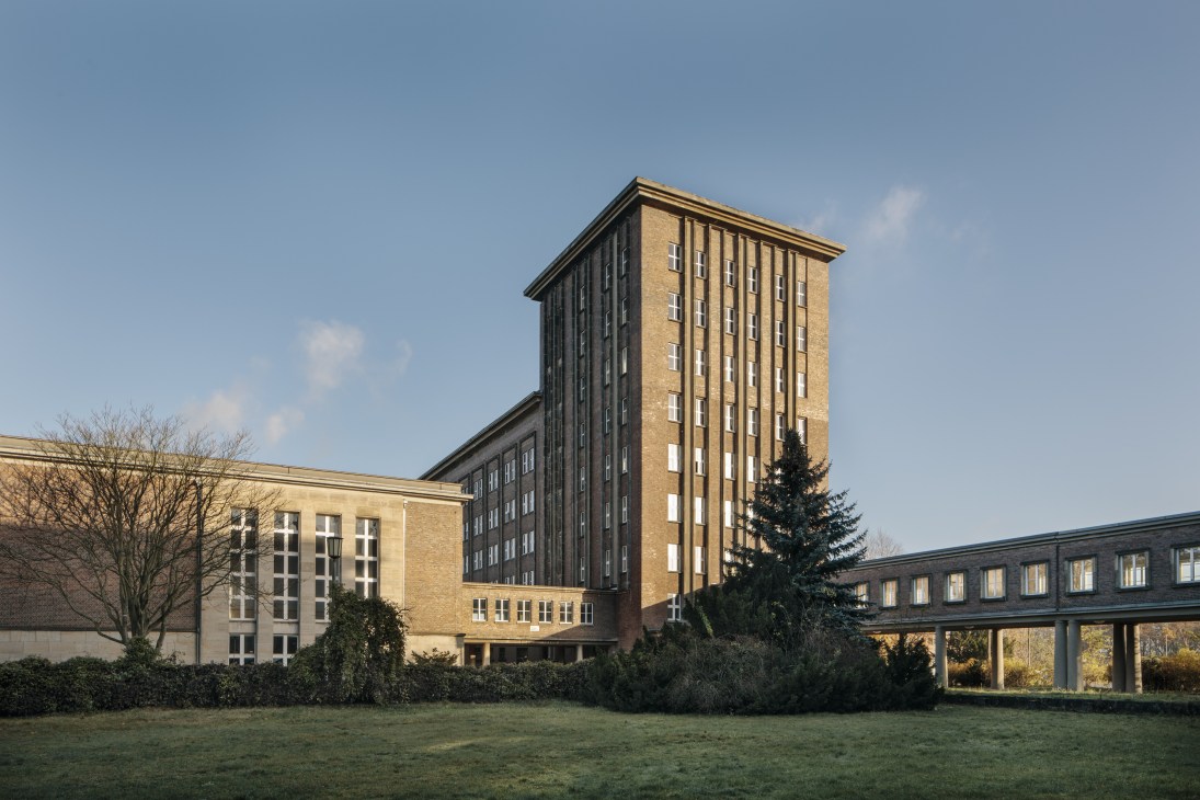 Exterior view of Funkhaus broadcasting house showing modernist brick facade with central office tower and connecting wing buildings under clear sky.