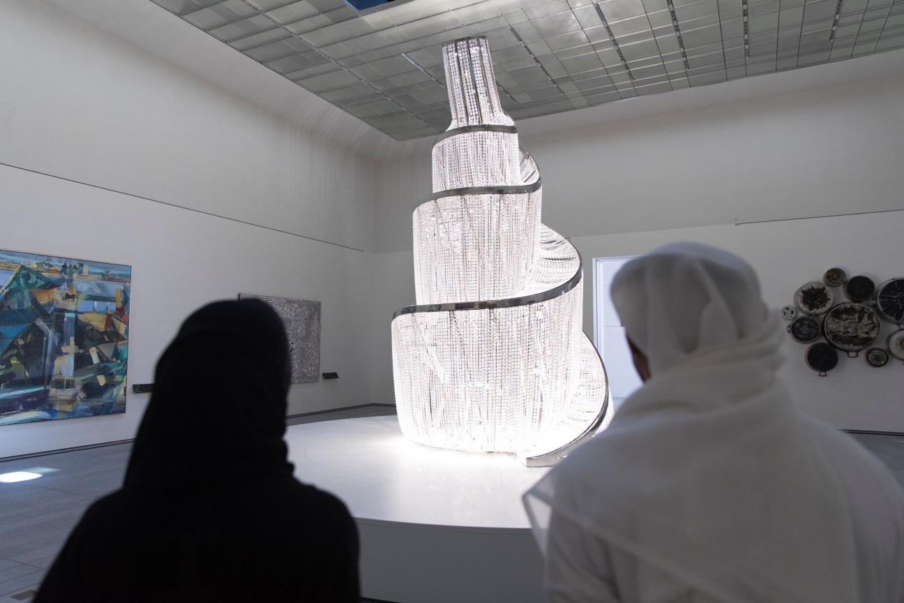 Visitors viewing Ai Weiwei's 'Fountain of Light', a white woven sculptural installation suspended from the ceiling in the Louvre Abu Dhabi.