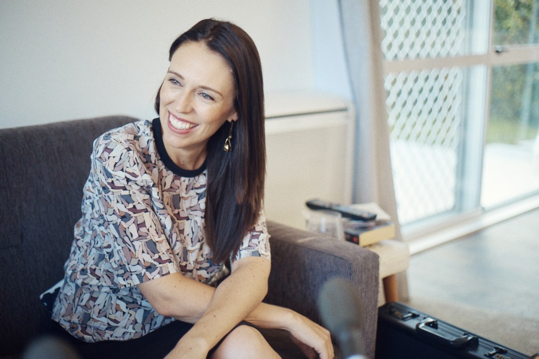 Jacinda Ardern smiling while seated on a couch in her Auckland home.