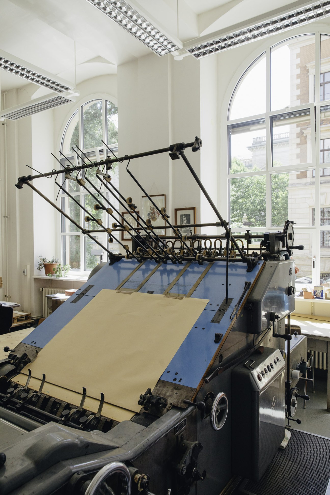 Adast Maxima Front letterpress printing machine at HGB with mechanical arms and blue frame.